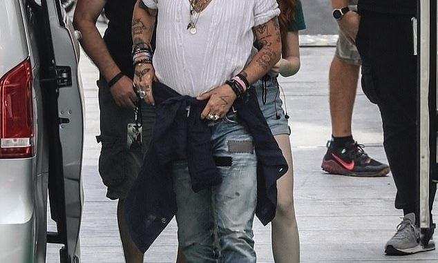 New flame? Johnny Depp appeared to be in a good mood as he arrived to a rehearsal at the Arena Santa Giuliana on Sunday in the presence of a red-haired mystery woman