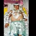 Basumatary asleep on a bed covered with ₹500 notes