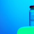 A Close-Up View of a Covid-19 Vaccine Vial on Blue Background
