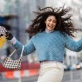 Happy woman jumping with shopping bags