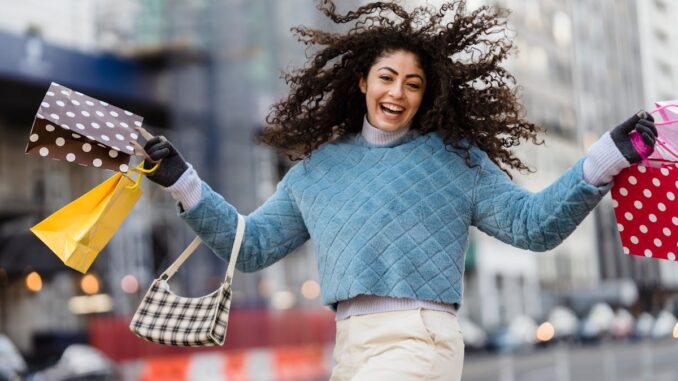 Happy woman jumping with shopping bags