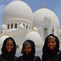 Three Women Taking A Photo In Front Of White Mosque