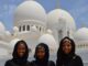 Three Women Taking A Photo In Front Of White Mosque