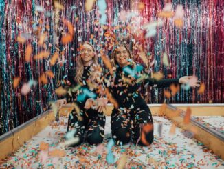 Two Women Kneeling While Throwing Confetti