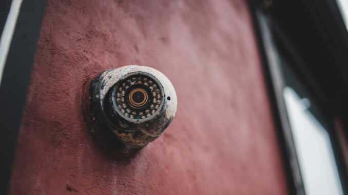 Old security camera on shabby building wall