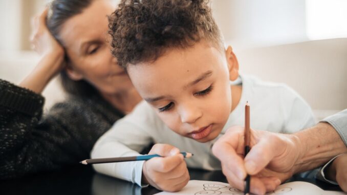 Boy in Black Shirt Writing on White Paper