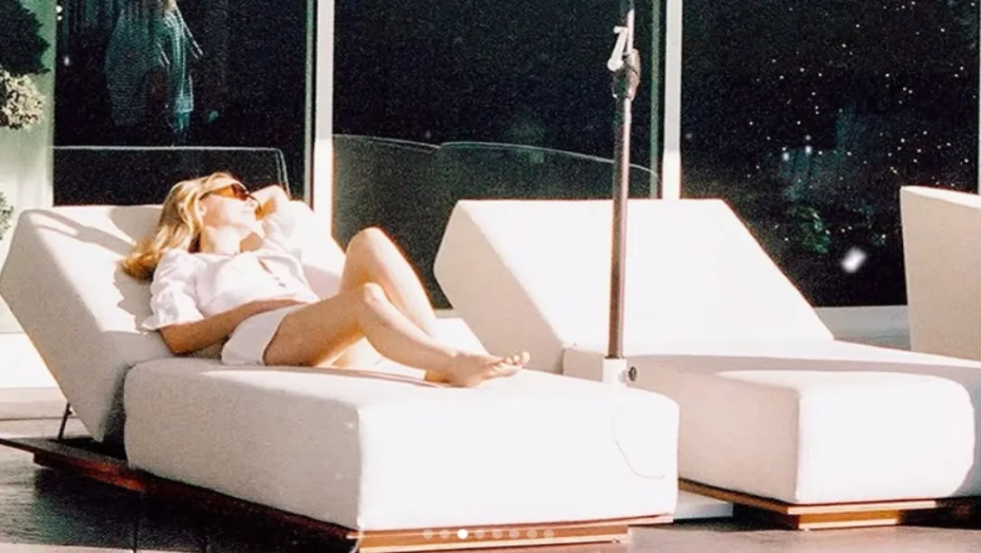 Julianne Hough posing in a bikini in front of a Christmas tree.