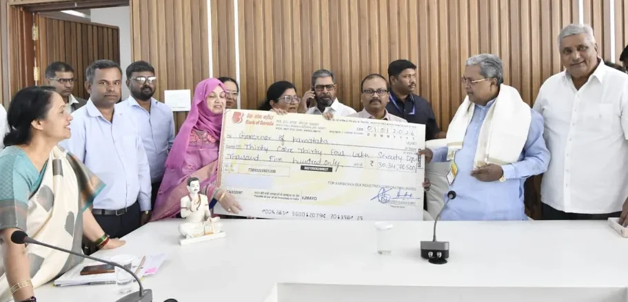 Chief Minister Siddaramaiah receiving a dividend check from KSIC officials.