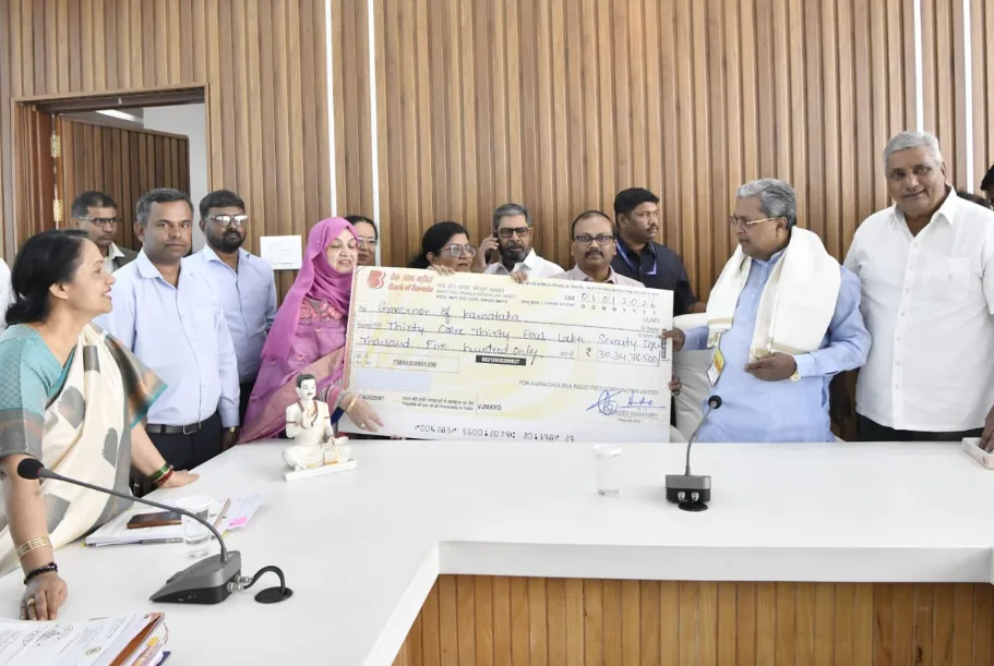Chief Minister Siddaramaiah receiving a dividend check from KSIC officials.