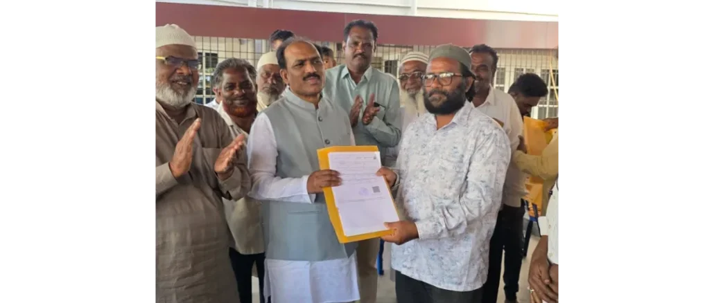 MLA Prasad Abbayya distributing title deeds to residents in Hubballi.