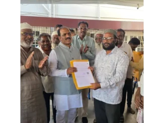 MLA Prasad Abbayya distributing title deeds to residents in Hubballi.