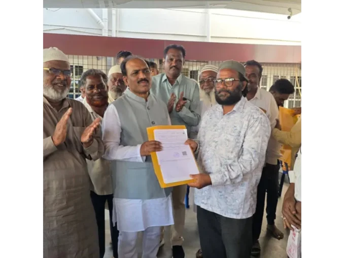 MLA Prasad Abbayya distributing title deeds to residents in Hubballi.