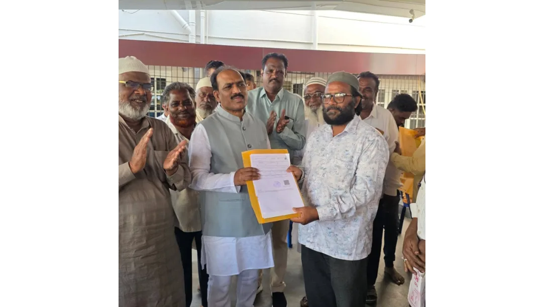 MLA Prasad Abbayya distributing title deeds to residents in Hubballi.