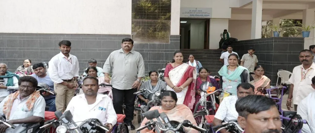 Prahlad Joshi distributing battery tricycles to persons with disabilities in Hubballi