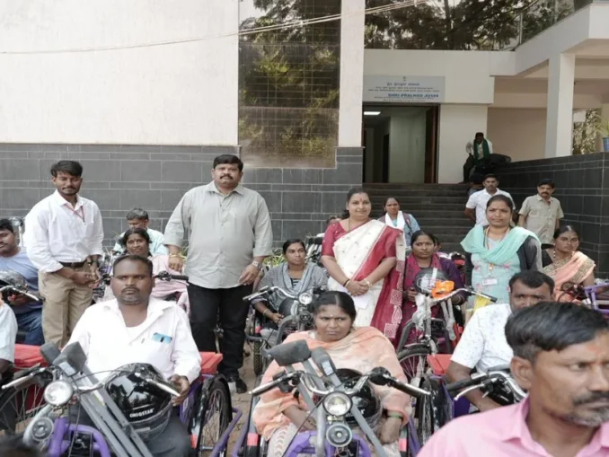 Prahlad Joshi distributing battery tricycles to persons with disabilities in Hubballi