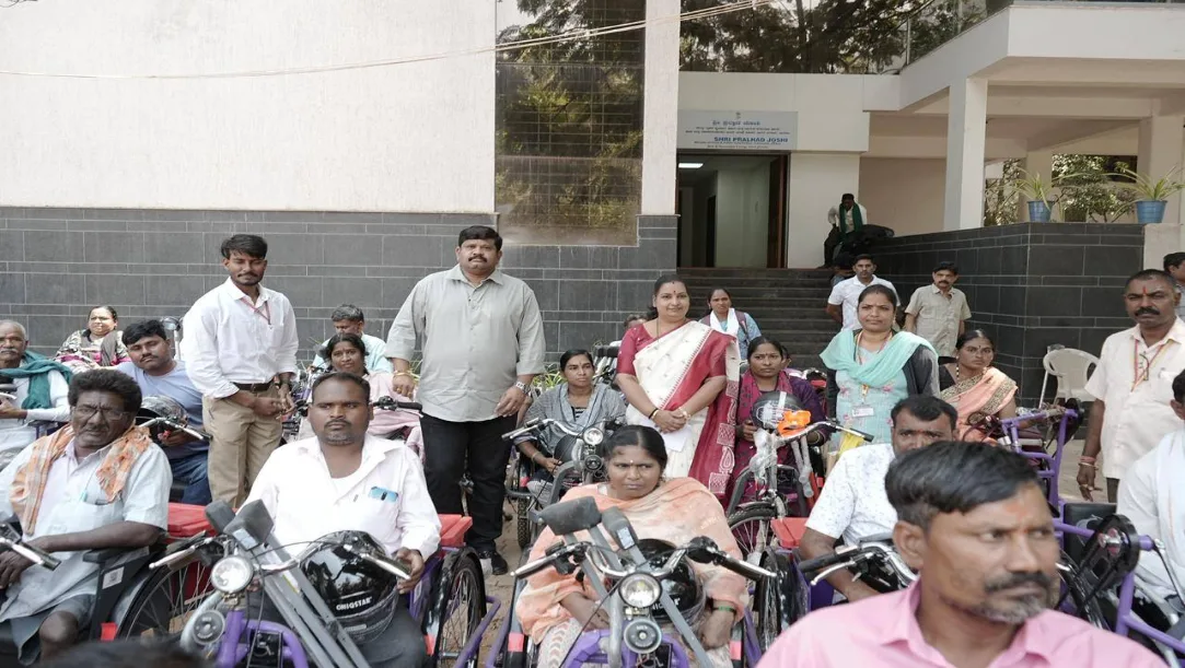 Prahlad Joshi distributing battery tricycles to persons with disabilities in Hubballi
