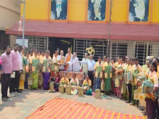 Shri Shivu Menasinakai distributing food kits and uniforms to municipal workers in Dharwad.