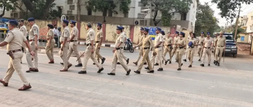 Hubballi-Dharwad police officers conducting a foot patrol in a crowded market area.