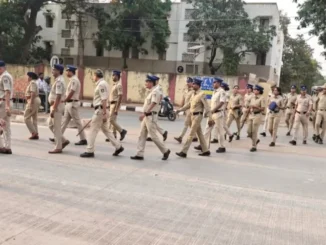 Hubballi-Dharwad police officers conducting a foot patrol in a crowded market area.