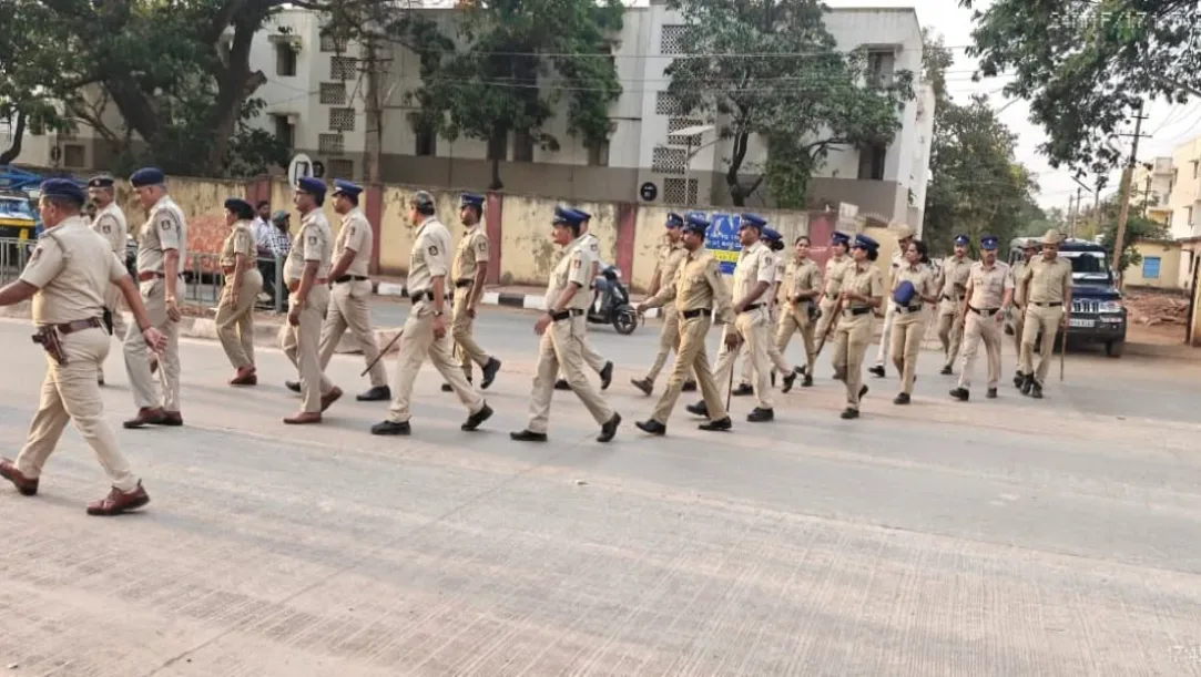 Hubballi-Dharwad police officers conducting a foot patrol in a crowded market area.