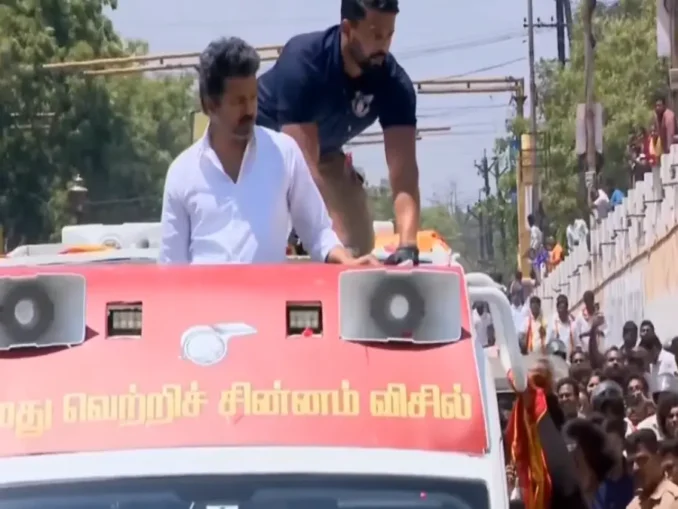 Thalapathy Vijay getting out of his car to help a couple who fell from a motorcycle.
