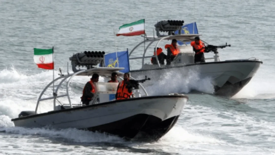 Iranian IRGC navy patrol boats in the Strait of Hormuz near a commercial oil tanker.
