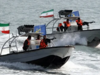 Iranian IRGC navy patrol boats in the Strait of Hormuz near a commercial oil tanker.