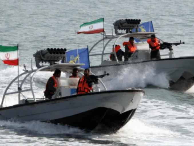 Iranian IRGC navy patrol boats in the Strait of Hormuz near a commercial oil tanker.