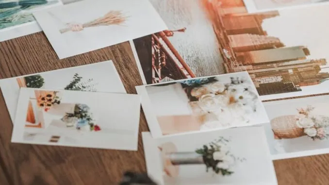 Printed photos scattered on wooden table